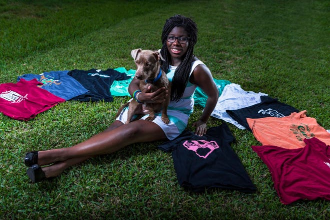 Danielle Dede poses with her club shirts and her dog Coco. Coco is a one-year-old Fox Terrier Wire Mix the Dede family recently adopted from Gainesville Pet Rescue.