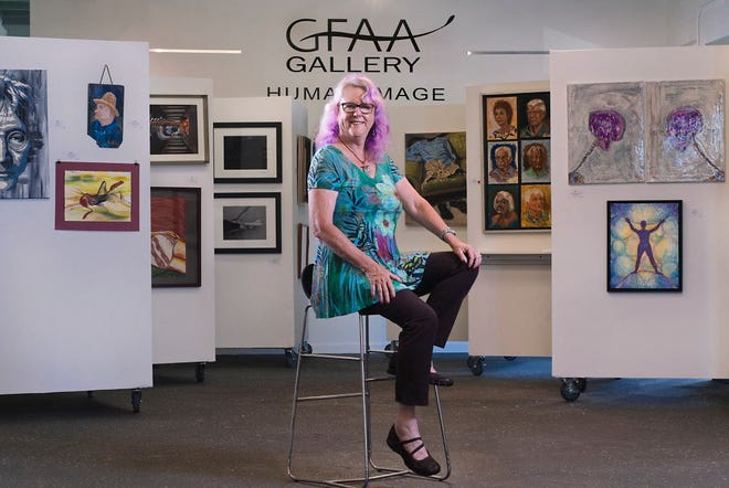 Karen Koegel, president of the Gainesville Fine Arts Association, in front of displayed artwork at the GFAA Gallery.