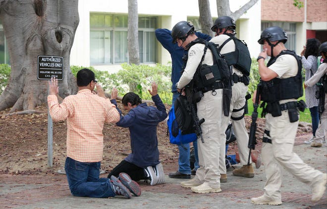 SWAT officers search students who were evacuated from the UCLA campus near the scene of a fatal shooting on Wednesday.