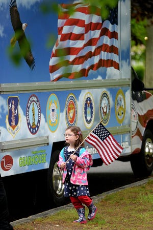 Parker Conlan, 4, holds her American Flag as she walks by Fence Force of the Pease Greeters during the Exeter Memorial Day gathering at Swasey Parkway.

Deb Cram/Seacoastonline