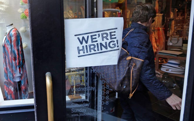 FILE - In this Wednesday, May 18, 2016, file photo, a woman passes a "We're Hiring!" sign while entering a clothing store in the Downtown Crossing of Boston. On Friday, June 3, 2016, the U.S. government issues the May jobs report. (AP Photo/Charles Krupa, File)