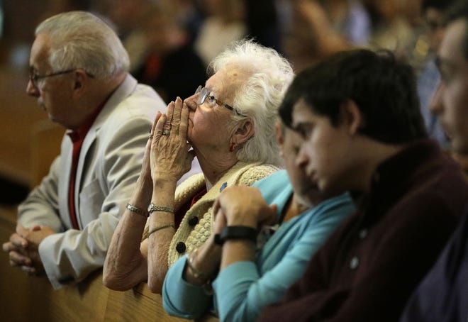 Parishioner Joanmarie Gorman, of Scituate, Mass., center, places her hands together during a planned final service at St. Frances X. Cabrini Church, Sunday, May 29, 2016, in Scituate. For more than 11 years, a core group of about 100 die-hard parishioners at the church have kept their parish open by maintaining an around-the-clock vigil in protest of a decision by the Roman Catholic Archdiocese of Boston to close it following the clergy sex abuse crisis. (AP Photo/Steven Senne)