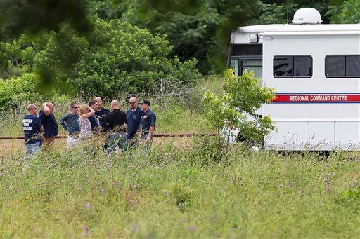 Emergency responders talk near the scene of an accident at Fort Hood at Owl Creek Park near Gatesville, Texas, on Thursday.