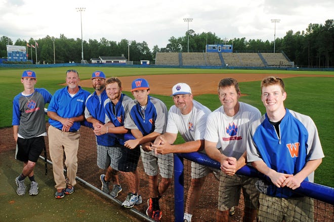 Father and son combos who have won state championships with Whiteville baseball, from left, Grayson Ward, Byron Ward, Brett Harwood, Hunter Harwood, Brooks Baldwin, Chuck Baldwin, David Smith and Taylor Smith pose for a photo near the dugout on the baseball field in Whiteville. Mike Spencer/StarNews