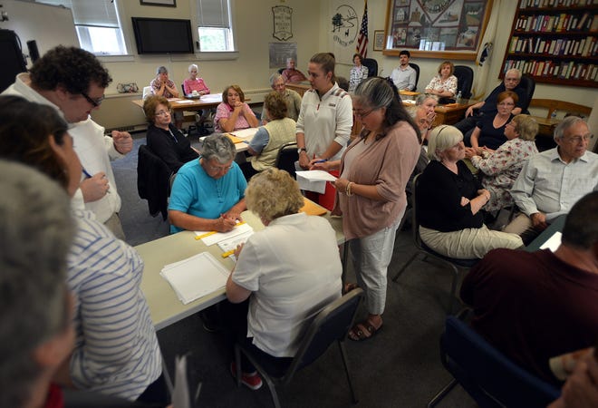 Jane Warden, left, and Carol McBride, both seated, count the first batch of ballots during a recount for the Board of Health seat in Hopkinton on Friday.

Daily News and Wicked Local Staff Photo/ Allan Jung
