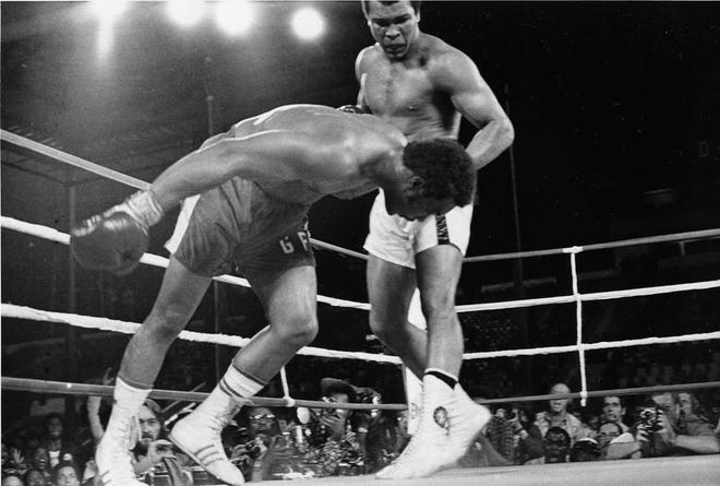Muhammad Ali watches as then-world heavyweight champion George Foreman goes down to defeat in their 1974 fight in Zaire. Foreman thought he would win easily.