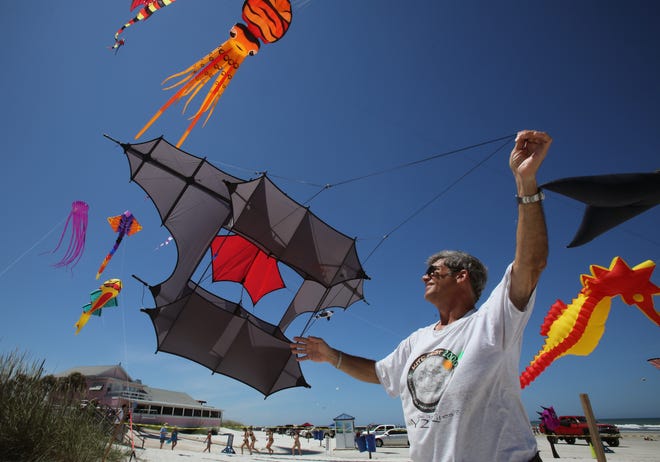 Kite flyer Luis Mugnani sends his cody kite skyward during the Kite Festival in New Smyrna Beach on Saturday. News-Journal/NIGEL COOK
