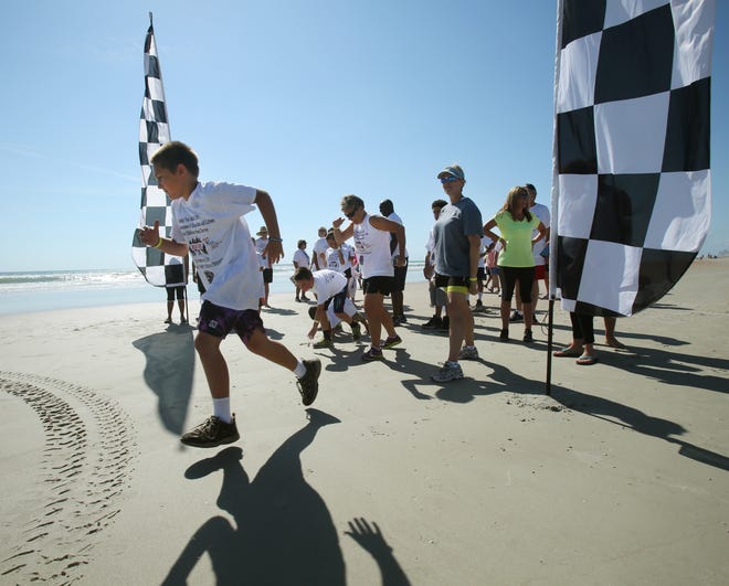 Runners and walkers head off the starting line during Guardian ad Litem family fun beach walk to benefit children in foster care hosted by the Volusia County Beach Safety Ocean Rescue on Saturday. News-Journal/NIGEL COOK