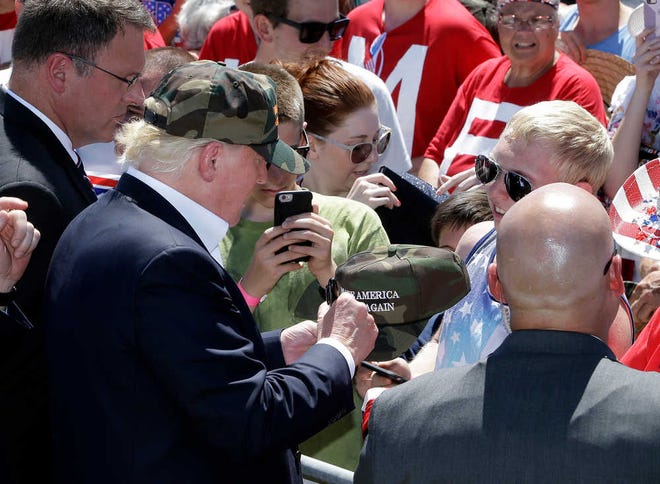 Republican presidential candidate Donald Trump autographs a hat after his campaign rally at the Redding Municipal Airport Friday, June 3, 2016, in Redding, Calif. (AP Photo/Rich Pedroncelli