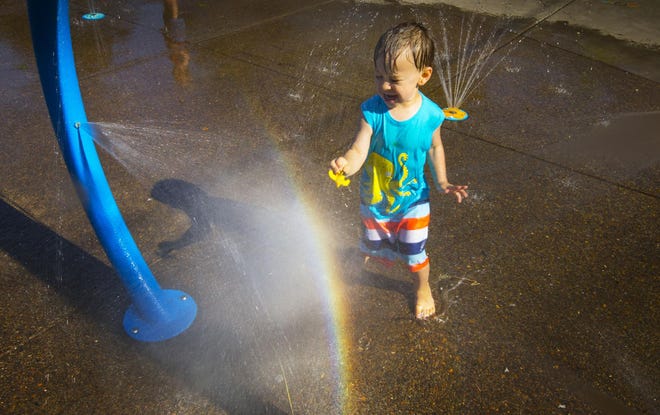 Three-year-old Ezekiel Cutting found a fun way to beat the heat by visiting the spray play area at Washington Park in Eugene with his family Friday afternoon. (Chris Pietsch/The Register-Guard)