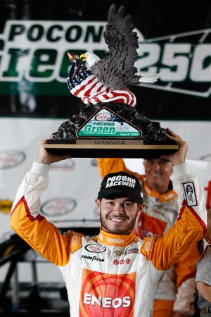 Kyle Larson poses with the trophy after winning the rain-shortened NASCAR Xfinity series race Saturday at Pocono Raceway in Long Pond, Pa. Larson led when the rain hit 53 laps into the scheduled 100-lap race. (AP Photo/Matt Slocum)
