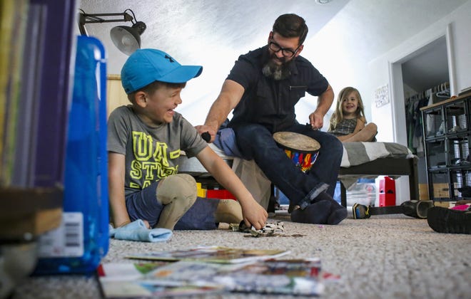 In this May 8, 2016, photo, Jude Hill, and his father, Greg, play in the boy's bedroom at home in Peoria, Ill. A double amputee as a result of a lawnmower accident two years ago, Jude underwent a number of surgeries and two sets of feet on his journey to recovery with the support of his family. (Andy Abeyta/Journal Star)