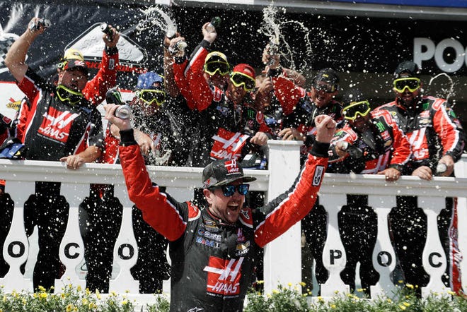Kurt Busch celebrates with his team in Victory Lane after winning the NASCAR Sprint Cup series auto race at Pocono Raceway, Monday, June 6, 2016, in Long Pond, Pa. (AP Photo/Matt Slocum)