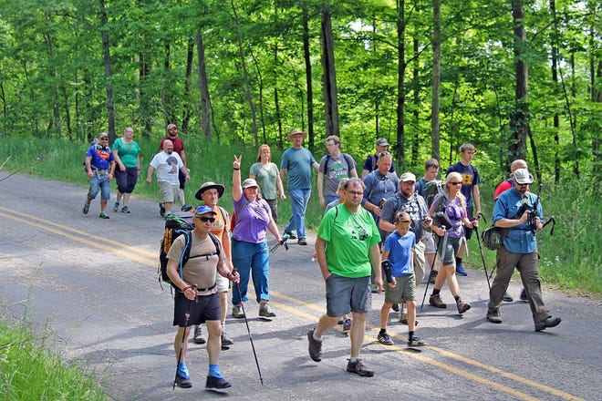 The hikers traveled a short way down the road before entering the forrest on a trailhead that took them through shaded pine woods and around a hidden pond. COREY MURRAY PHOTO