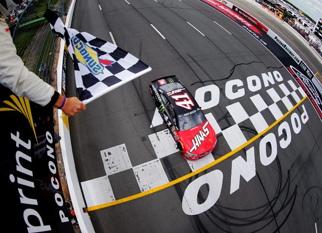 Kurt Busch's No. 41 Stewart-Haas Racing Chevrolet flashes across the finish line to win Monday's race at Pocono Raceway. GETTY IMAGES/JONATHAN FERREY