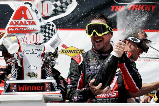 Kurt Busch celebrates with his team in Victory Lane on Monday after winning the NASCAR Sprint Cup series race at Pocono Raceway in Long Pond, Pa. Rain pushed the race, originally scheduled for Sunday, to be run one day later.