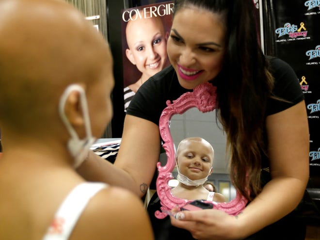 Lea Montes shows Miah her face after finishing her makeup during GlamWars at the UF Health Shands ChildrenÕs Hospital on Tuesday in Gainesville.