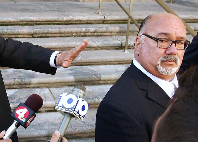 Lobbyist John Raphael, seen moving away from reporters' microphones after a court appearance in October, has refused to implicate others after pleading guilty to extorting campaign contributions from red-light camera vendor Redflex.