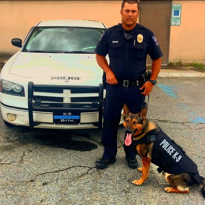 Officer Justin Eddins stands with his K-9, Brix, who is wearing a new protective vest. Contributed photo