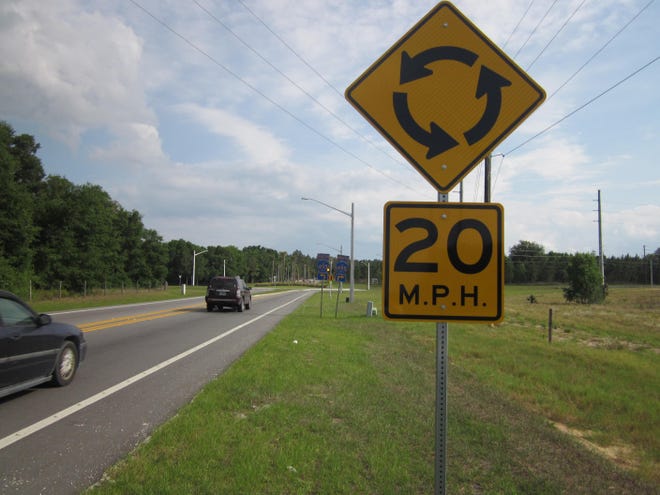 Signs direct traffic to slow while entering the roundabout in rural Lake County. In addition to this posted 20 mph sign, a signal farther ahead shows motorists how fast they are traveling into the roundabout. NEWS-JOURNAL/MARK HARPER