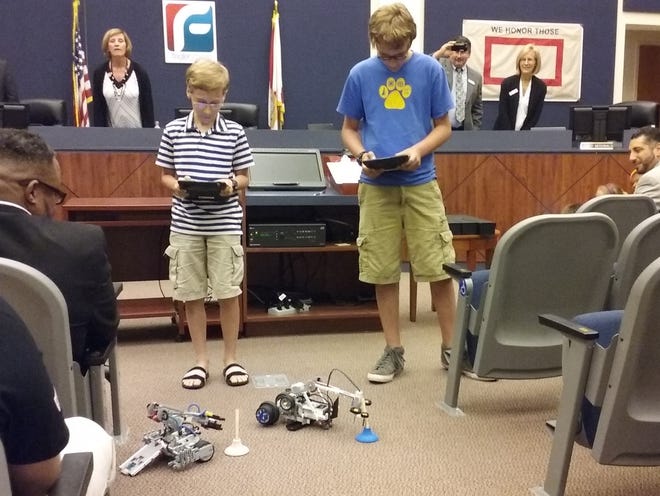 Two Wadsworth Elementary sixth-graders in the school's STEM Academy demonstrate their robots during Tuesday's Flagler County School Board meeting. NEWS-JOURNAL/SHAUN RYAN