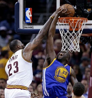 Cleveland Cavaliers forward LeBron James (23) drives on Golden State Warriors forward Draymond Green (23) during the first half of Game 3 of basketball's NBA Finals in Cleveland, Wednesday, June 8, 2016. (AP Photo/Tony Dejak)