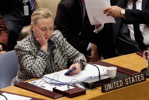 FILE - In this March 12, 2012 file photo, then-Secretary of State Hillary Rodham Clinton checks her mobile phone after her address to the Security Council at United Nations headquarters. The names of CIA personnel could have been compromised not only by hackers who may have penetrated Hillary Clinton’s private computer server or the State Department system, but also by the release itself of tens of thousands of her emails. (AP Photo/Richard Drew, File)