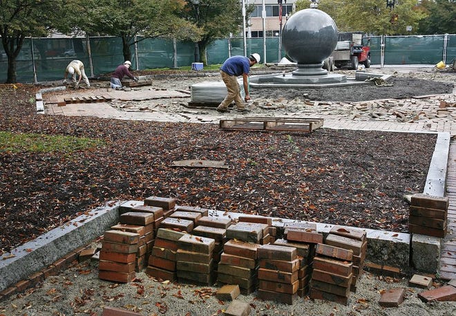 In this October 2013 file photo, construction workers removed bricks from the city's original "Walk of Names." Donors will be able to pick up these original bricks starting later this month.