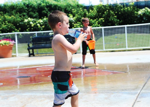 Colten Deweese, 4, of Pekin, takes a break from playing in the fountains to drink some water at Pekin Riverfront Park Wednesday afternoon. Temperatures are expected to reach the mid 90s this weekend and health officials are encouraging those in the heat to take the right precautions.