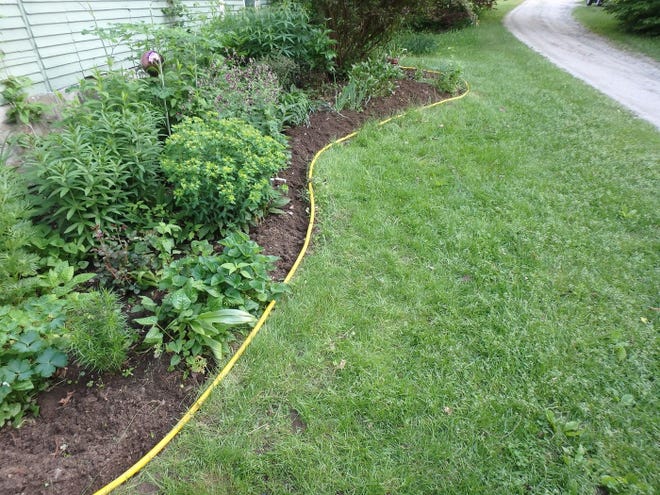 Edging a flower bed not only makes the yard look neater, the act of edging can create a "moat" that grass can't easily cross. Photo courtesy of Henry Homeyer