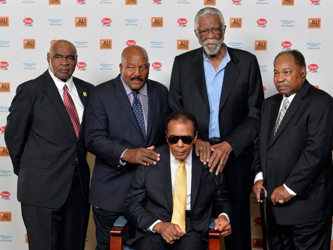 In this Sept. 27, 2014, file photo, back row from left, John Wooten, Jim Brown, Bill Russell, and Bobby Mitchell stand behind Muhammad Ali before the start of the Ali Humanitarian Awards ceremony in Louisville, Ky. The death of Muhammad Ali left a profound effect on many, even fellow legends.