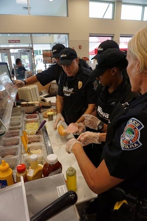 Sarasota police officers managed to create 24 sandwiches to win a charity "Hoagies for Heroes" event at the opening of the first Wawa store in Sarasota County, at 3703 N. Washington Blvd. SARASOTA