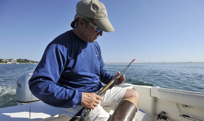 Greg Skomal prepares a tagging dart while heading out for a day of shark-tagging off Chatham in 2014. He will give a talk about white shark research in Marion Friday. 

STEVE HEASLIP/CAPE COD TIMES FILE