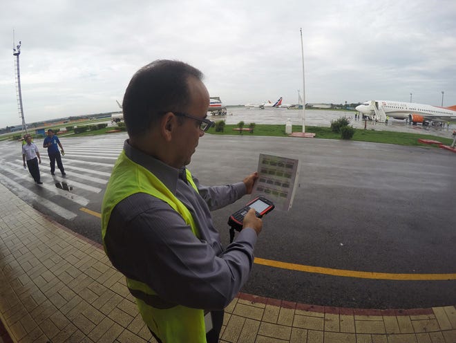 In this Thursday, June 9, 2016, photo, Galo Beltran, Cuba country manager for American Airlines, tests a handheld baggage scanner at Havana's Jose Marti International Airport. Beltran is based in Dallas. The Department of Transportation said Friday that six airlines: American, Frontier, JetBlue, Silver Airways, Southwest and Sun Country, have been selected for routes to nine Cuban cities other than Havana. (AP Photo/Scott Mayerowitz)
