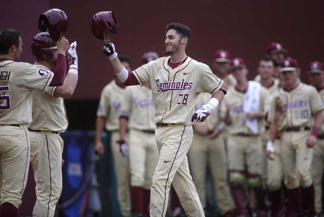 Florida State's Dylan Busby is congratulated at home plate after a home run against South Alabama during an NCAA college regional baseball game in Tallahassee, Fla., Sunday, June 5, 2016. (Joe Rondone/Tallahassee Democrat via AP) NO SALES; MANDATORY CREDIT