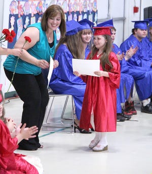 Tarynn Pierce (right) receives her graduation certificate from Jeanine Medrano.