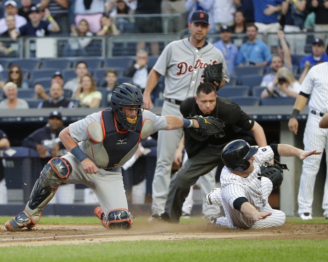 Detroit Tigers catcher James McCann tags out Yankees catcher Brian McCann (34) as home plate umpire Carlos Torres and starting pitcher Mike Pelfrey look on during the first inning of Friday night's game at the Stadium. The Associated Press