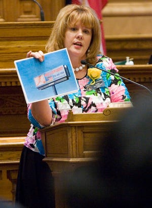 ILE - In this March 8, 2011 file photo, Sen. Renee Unterman, R-Buford, shows fellow senators an example of a billboard while addressing the senate chamber on a bill in Atlanta. In 2014, Unterman helped lead an effort to shut down Medicaid expansion in Georgia. Now the chair of the Senate health committee wants her colleagues to reconsider years of opposition to any form of Medicaid expansion. (AP Photo/John Amis)