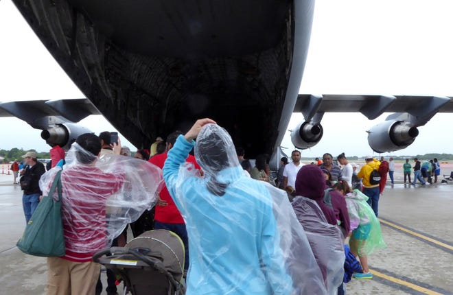 People try to get a last-minute look at the C-17 Globemaster III on Saturday as rain fell, leading to an early end to the Rhode Island National Guard Open House and Air Show, at Quonset Point. The Providence Journal/Sandor Bodo