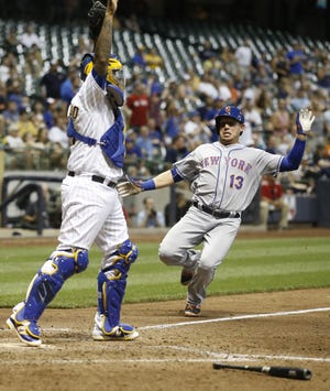 Mets' Asdrubal Cabrera scores the eventual game-winner on a fielder's choice in the 11th inning Friday night in Milwaukee. The Brewers catcher is Martin Maldonado. The Associated Press