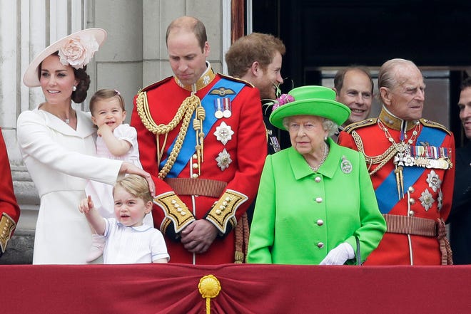 Britain's Queen Elizabeth II looks across the crowd with Prince Philip, right, Prince William, centre, his son Prince George, front, and Kate, Duchess of Cambridge holding Princess Charlotte, left, on the balcony during the Trooping The Colour parade at Buckingham Palace, in London Saturday. Hundreds of soldiers in ceremonial dress have marched in London in the annual Trooping the Colour parade to mark the official birthday of Queen Elizabeth II. The Trooping the Colour tradition originates from preparations for battle, when flags were carried or "trooped" down the rank for soldiers to see.