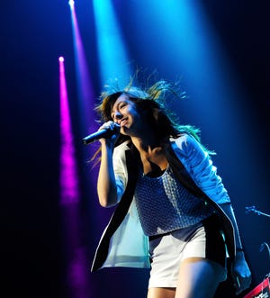 In this Oct. 25, 2013 photo, Christina Grimmie performs in concert at the Bridgestone Arena, in Nashville, Tenn. The singer, who was most widely known from her appearances on "The Voice," was fatally shot as she signed autographs Friday after performing in Orlando, Florida.