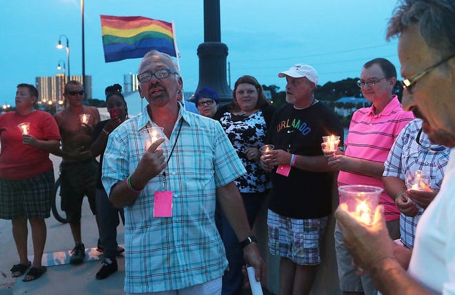 Members of The Pride of the Panhandle sing "Amazing Grace" while holding a candlelight vigil Sunday night to remember the 50 killed and 53 injured in the Pulse nightclub shooting, the deadliest shooting in U.S. history.