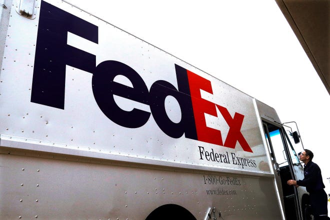 FILE - In this Dec. 18, 2014 file photo, a Federal Express driver returns to his truck after delivering a package to a business in Springfield, Ill. Prosecutors said Monday, June 13, 2016, that FedEx delivered packages containing illegal prescription drugs for internet pharmacies even after it noticed that authorities were cracking down on the businesses, as a trial began over drug trafficking charges against the shipping giant.