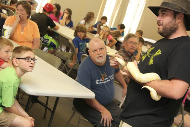 Dusty Jones shows off his albino bald python Friday morning at the Litchfield United Methodist Church, part of the Litchfield District Library's summer reading program. ANDY BARRAND PHOTOs