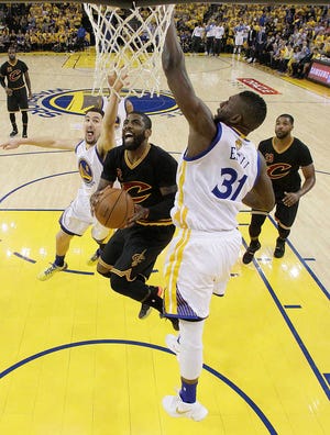 Cleveland's Kyrie Irving drives between Golden State's Festus Ezeli (31) and Klay Thompson during Game 5 of the NBA Finals on Monday in Oakland, California. Irving scored 41 points, as did teammate LeBron James, in the Cavaliers' 112-97 win.