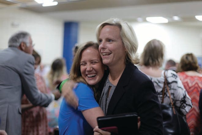 New Craven County Schools' Superintendent Meghan Doyle embraces Craven County's 2015-16 Teacher of the Year Stephanie Edwards during a reception welcoming Doyle to the community at the final school board meeting for the 2015-16 school year.