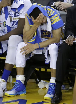 Warriors guard Stephen Curry sits on the bench during the second half of Game 5 on Monday night. The Associated Press