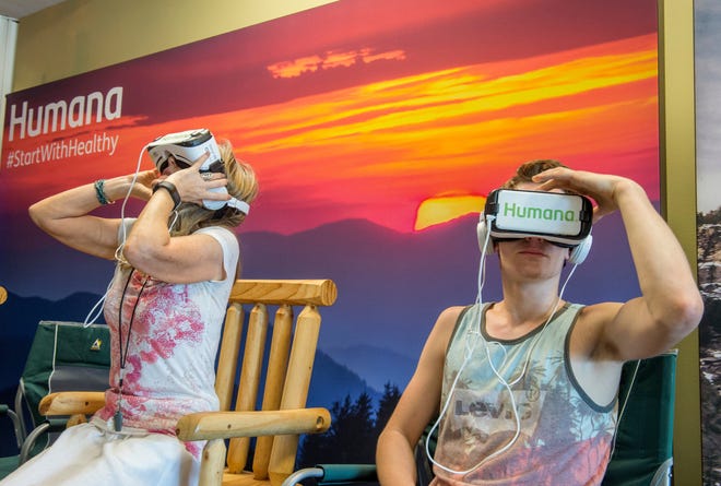DAVID ZALAZNIK/JOURNAL STAR Humana Guidance Center operations support employee Cindy Womack and her son, Blake Adams, 16, take a virtual tour of a national park in the company's lobby in Peoria Wednesday. The use of the device is a partnership with the National Park Service as a way to promote the health benefits of outdoor activity.
