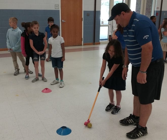 Christian Bell, director of junior golf at Palm Harbor Golf Club, instructs Wadsworth Elementary School first-graders in the fundamentals of the game earlier this year. Bell and Flagler County resident Renny Roker are developing a new program, Greens for Teens, designed to help students on and off the golf course. Tutors and mentors will play a key role in the teens' academic success and career aspirations. NEWS-JOURNAL FILE/SHAUN RYAN